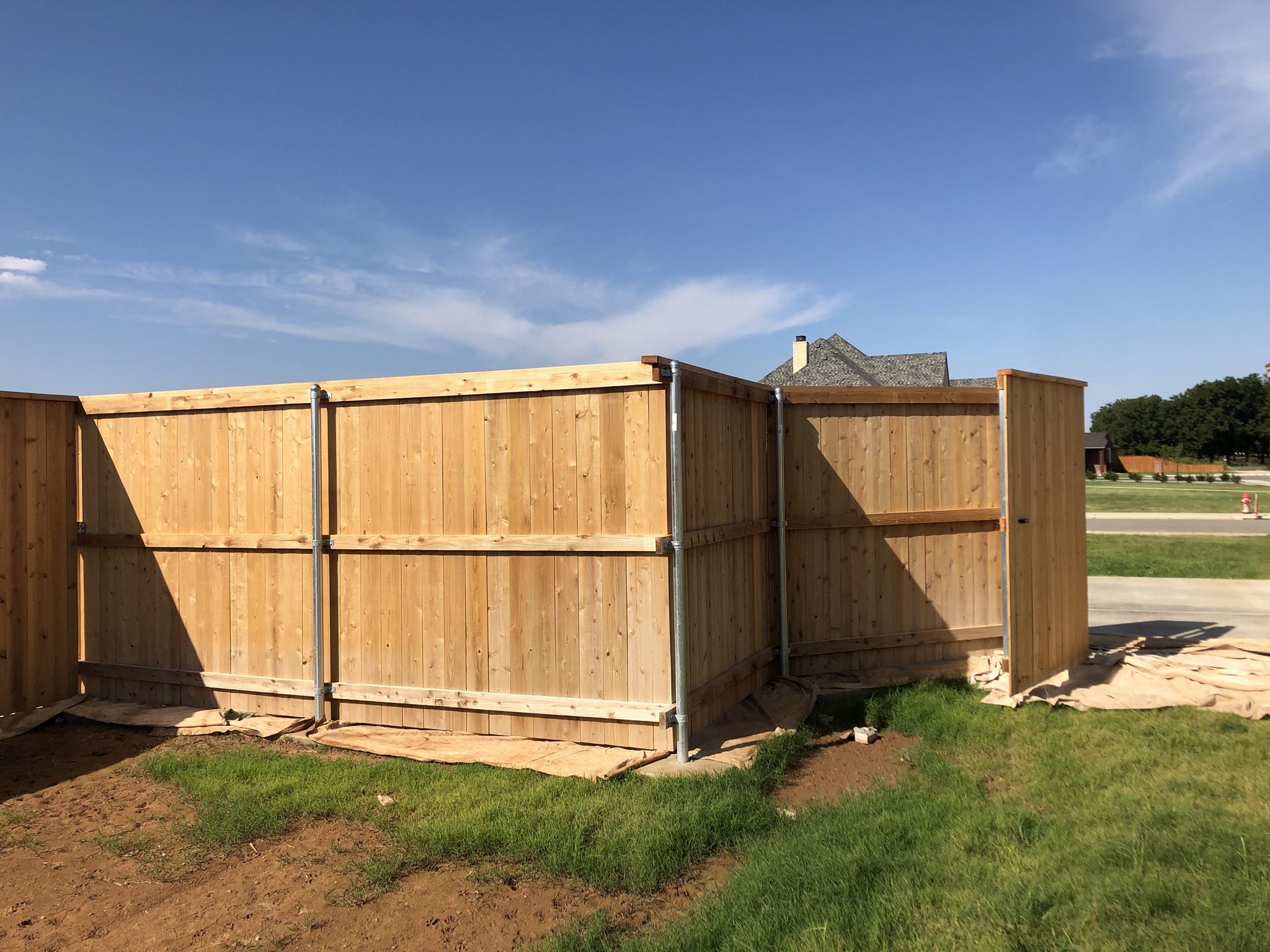 Long stained wood privacy fence next to a home